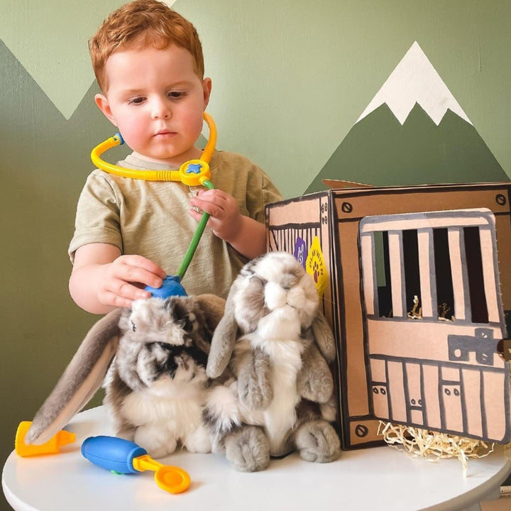 Boy playing with his Living Nature Rabbit Plush Toys