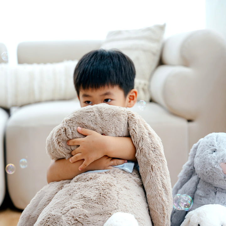 Boy hugging giant jellycat bunny