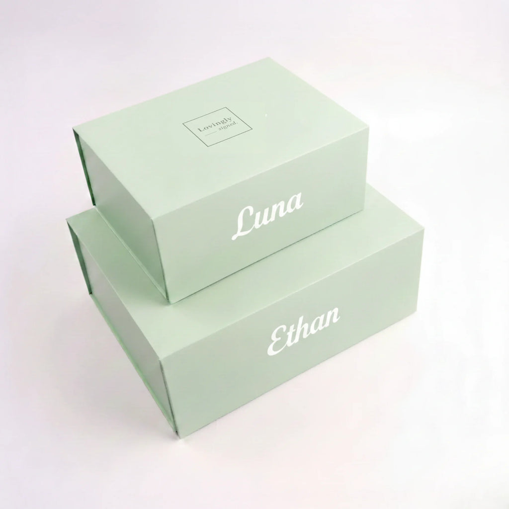 Two silky green boxes personalised with 'Reina' and 'Lovingly Signed' text on a white background