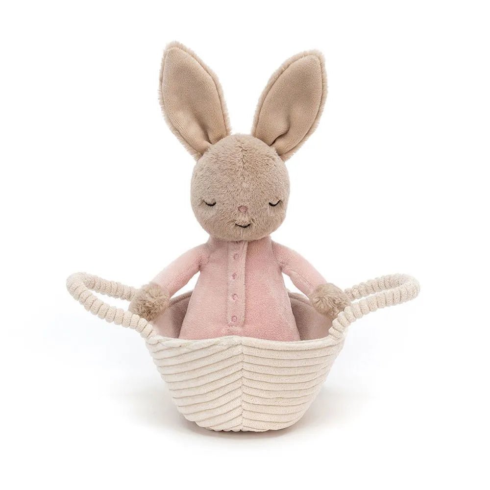Rock-a-Bye Bunny nestled in a beige basket, with a soft praline-colored fur coat and sweet, dreamy expression.
