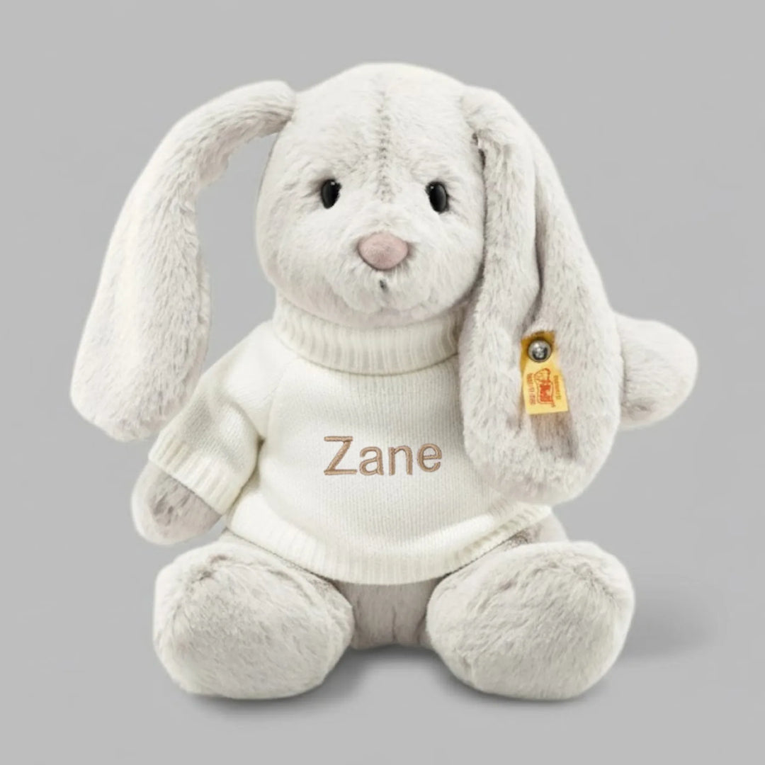 Grey plush bunny toy with 'Zane' embroidered on it