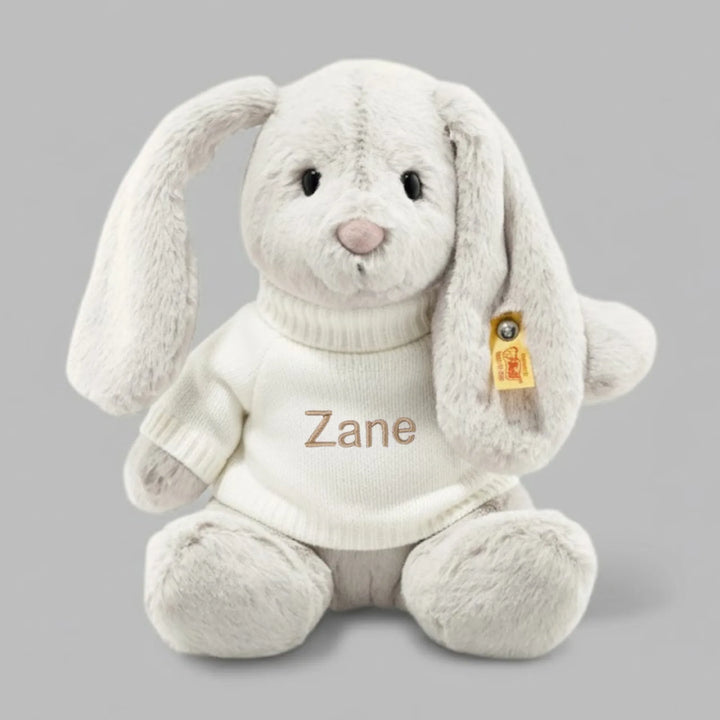 Grey plush bunny toy with 'Zane' embroidered on it