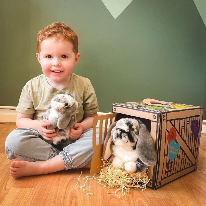 Boy playing with his Living Nature Rabbit Plush Toys