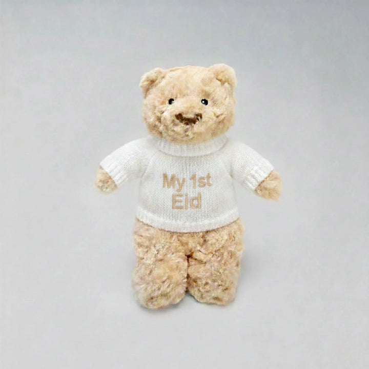 Teddy bear wearing a white shirt with 'My 1st Eid' text on a gray background