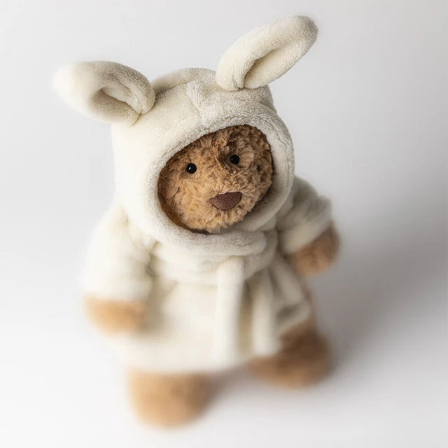 Adorable Jellycat Bartholomew Bear Bathrobe plush toy dressed in a fluffy cream robe with hood