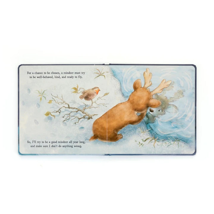 Open “Mitzi Reindeer’s Dream” board book showing the young reindeer looking at its reflection in the snow while learning how to become one of Santa’s reindeer.
