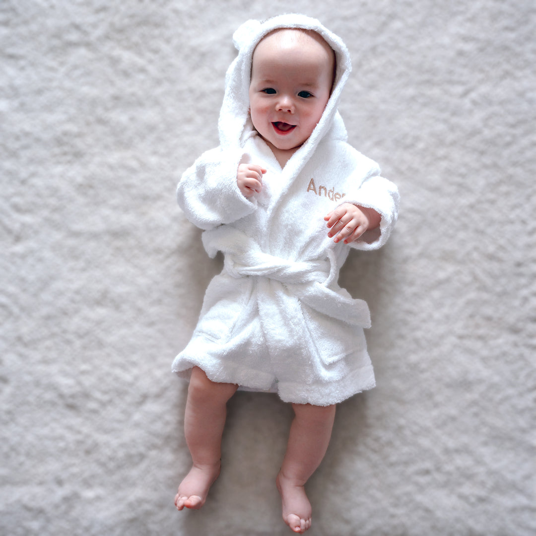 A baby is wrapped in a soft, cozy light pink blanket