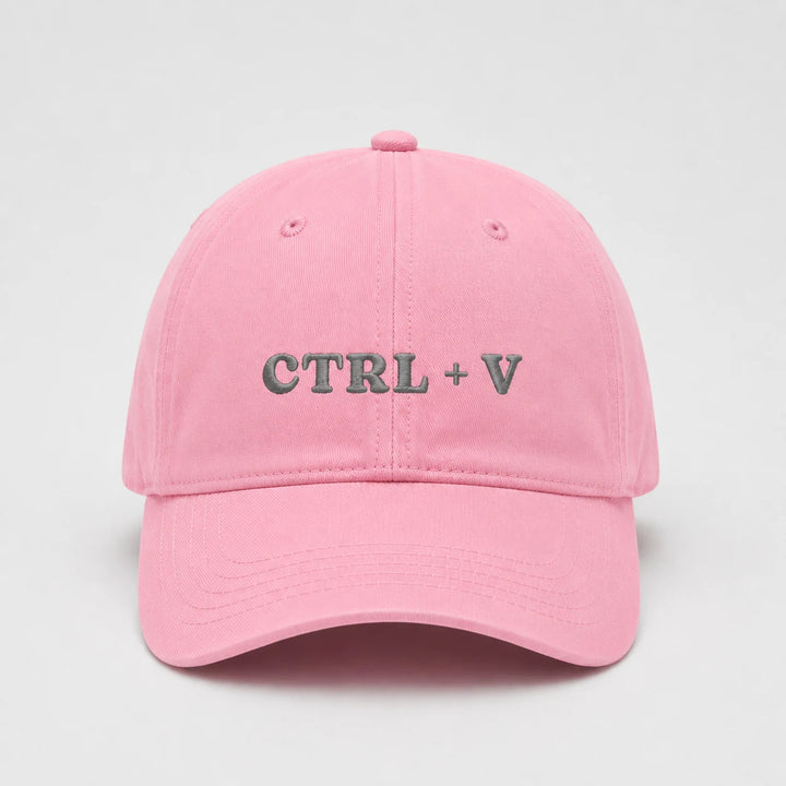 Pink cap with 'CTRL + V' text on a light gray background