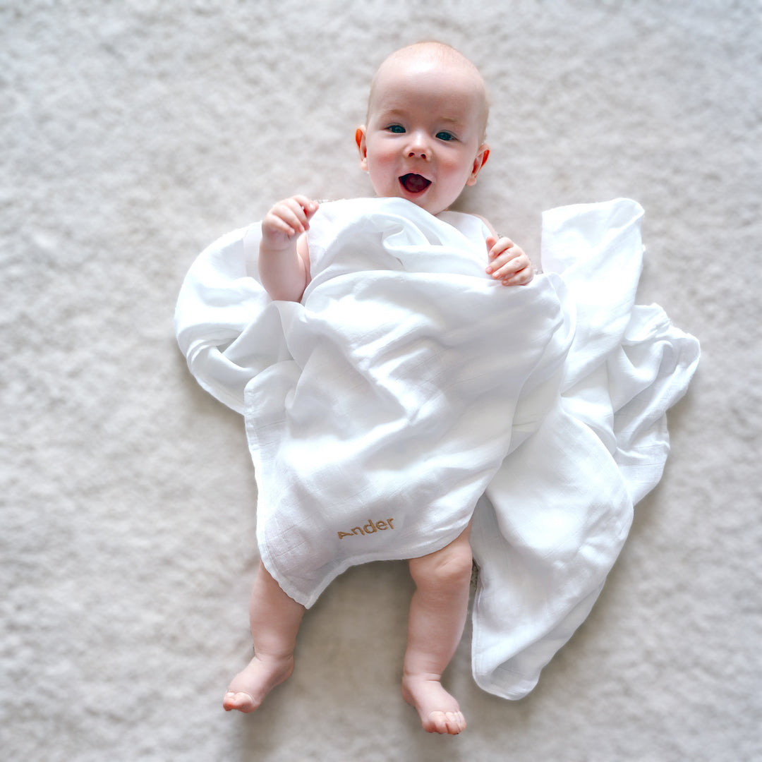 baby covered with white Blanket 