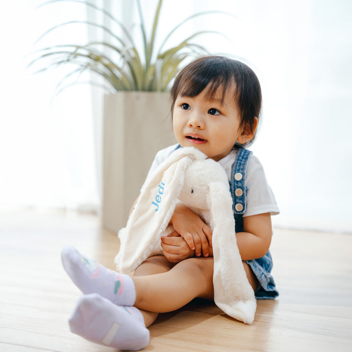 baby playing with pernolished Jellycat toy