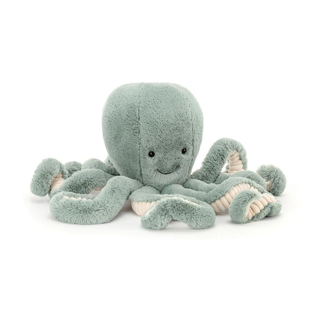 Sage green octopus soft toy with a sweet embroidered smile, black eyes and multiple curled tentacles with cream corduroy undersides.