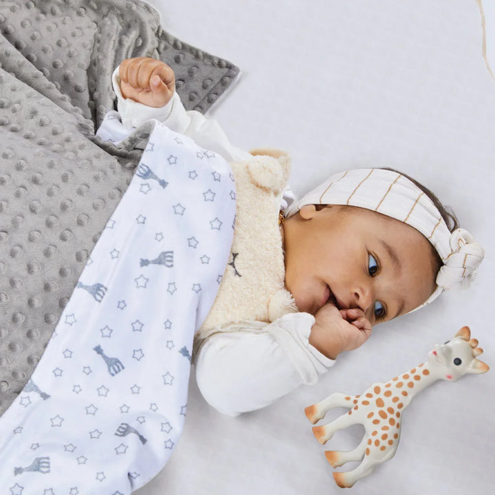 Baby Lying Under Sophie la girafe Sophie’doux Grey Blanket with Sophie Teether