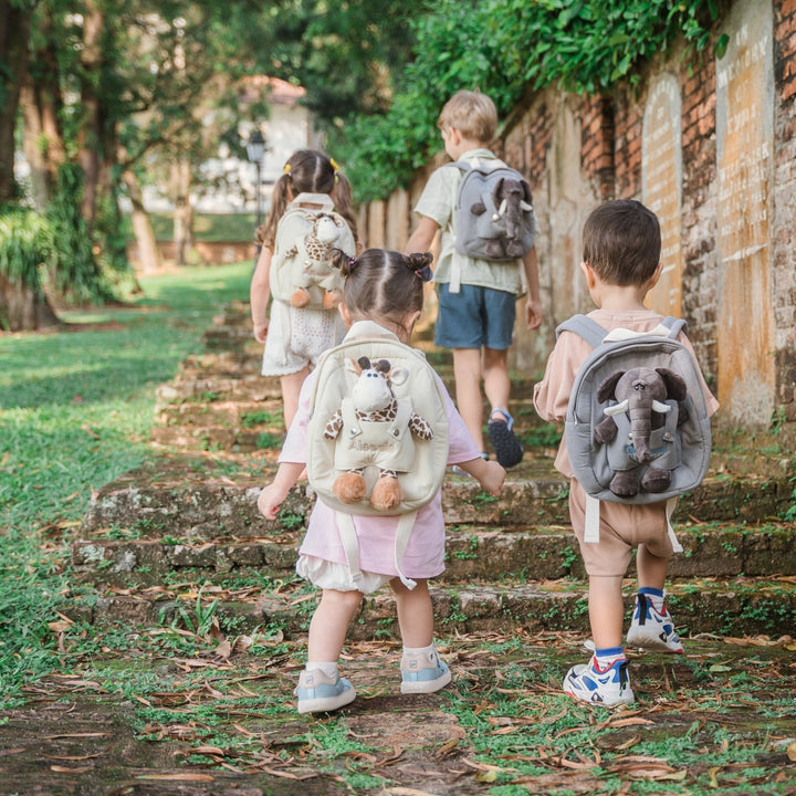 Toddlers carrying their own personalised backpack going up stairs