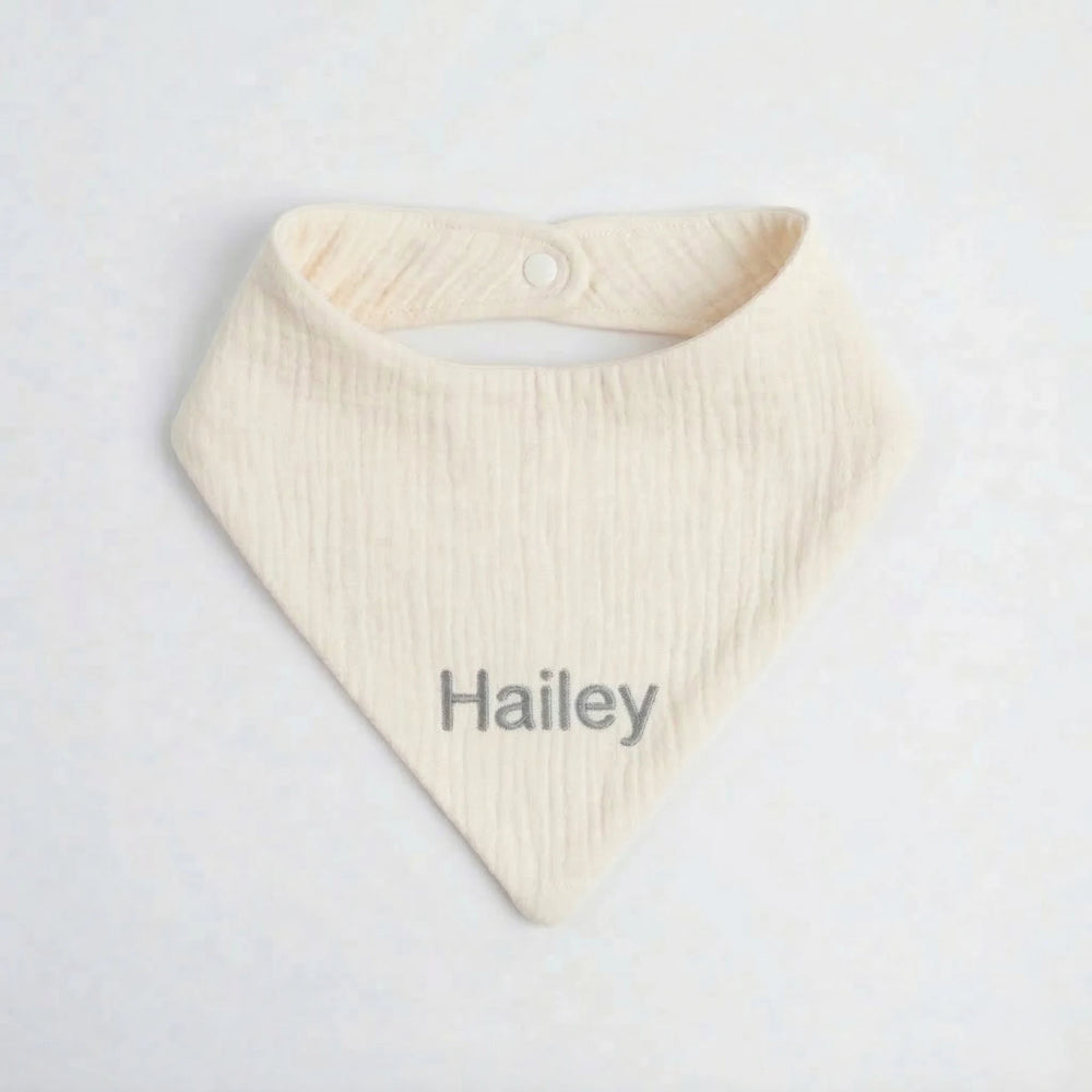 Cream baby bib with 'Hailey' embroidered in Grey thread