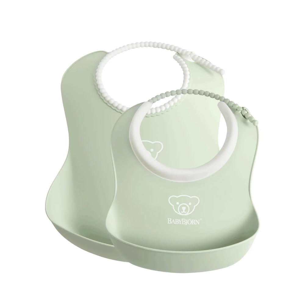 Green BabyBjörn 2-pack silicone baby bibs with adjustable neck straps.