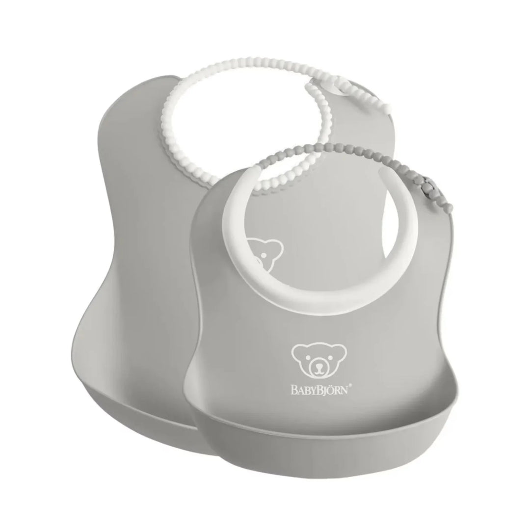 Soft and flexible Grey BabyBjörn bibs with spill pocket for easy mealtime cleanup.