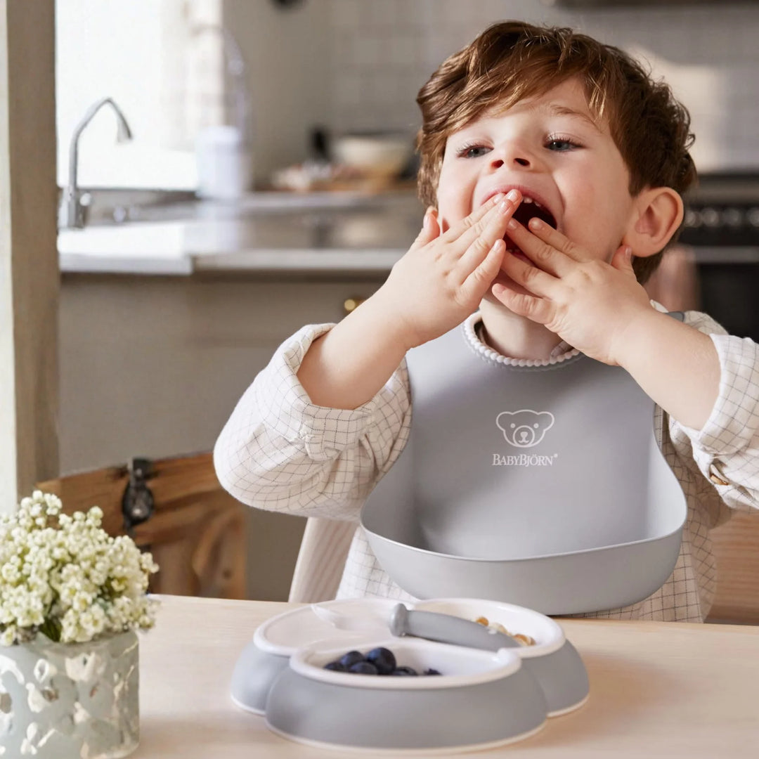 Ergonomic BabyBjörn baby feeding set designed for easy self-feeding.