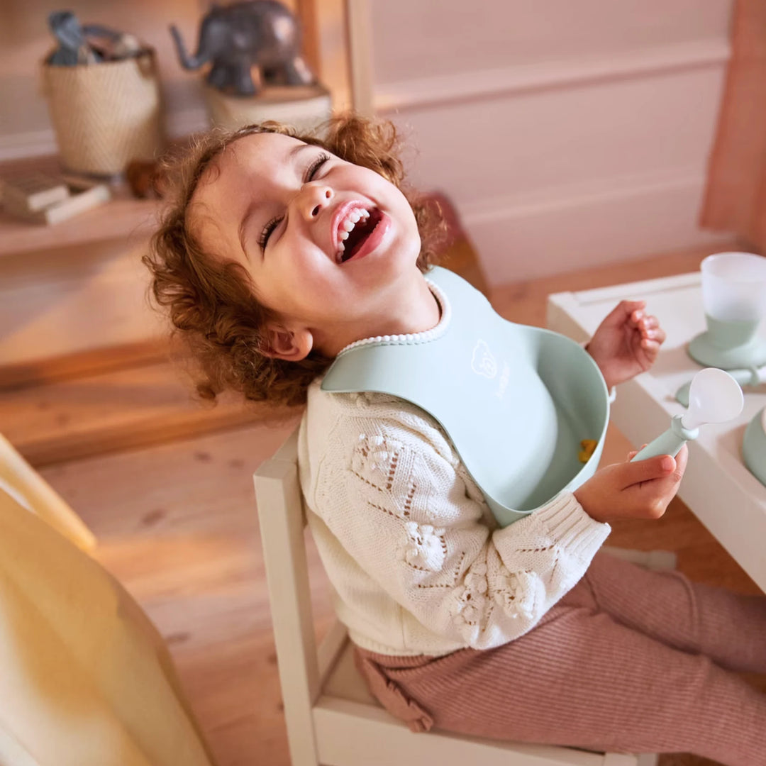 Adjustable BabyBjörn bibs with practical pocket for food and crumbs.