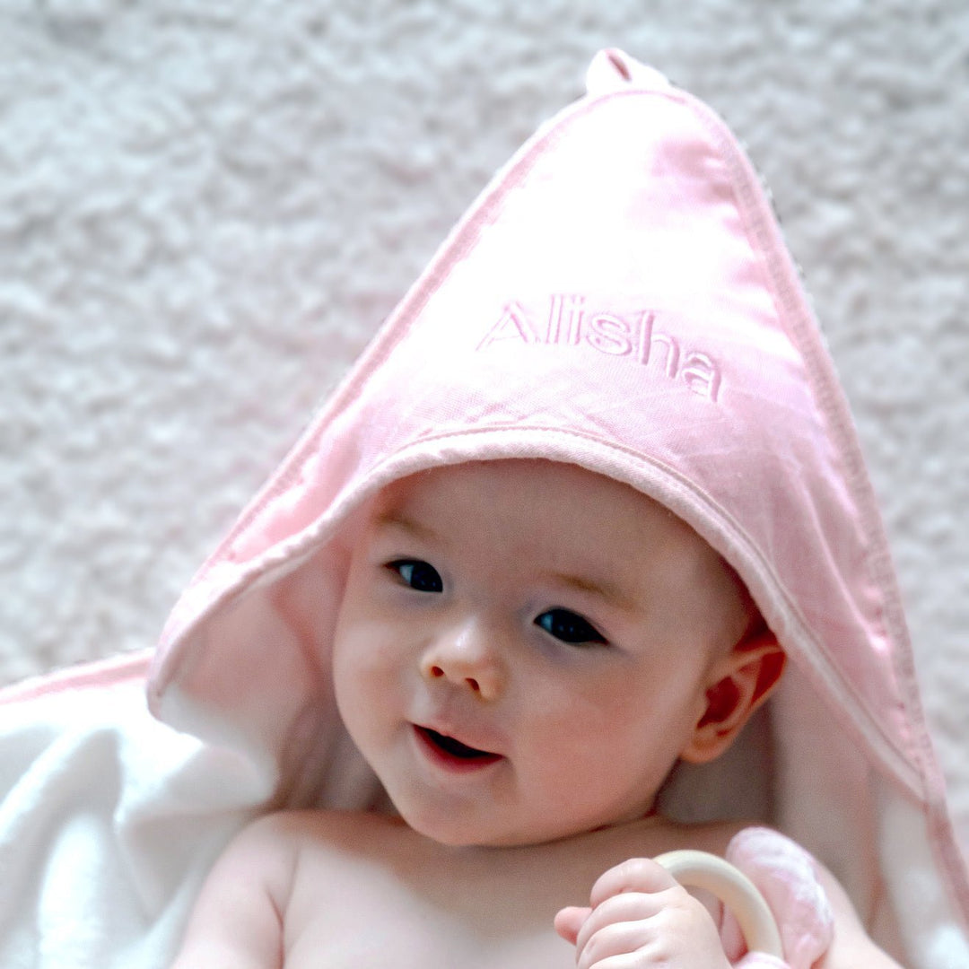 Baby wearing Pink Hooded Towel with personalisation "Alisha" in Pink thread

