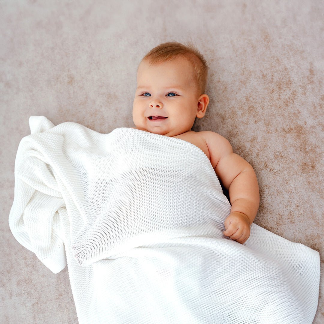 White bamboo cellular blanket covering over baby