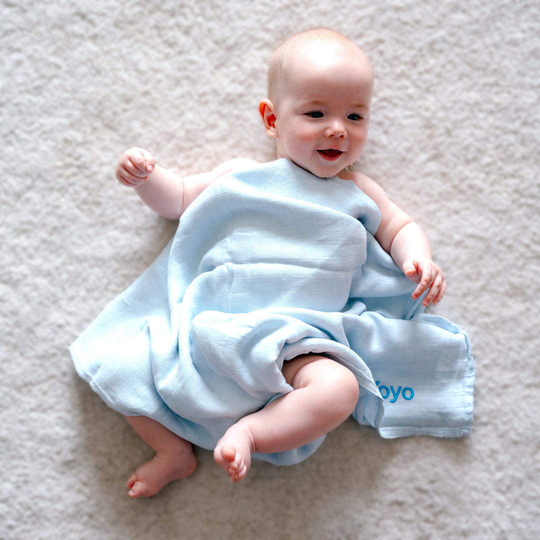 Baby wrapped in a blue bamboo swaddle with 'Yoyo' personalised