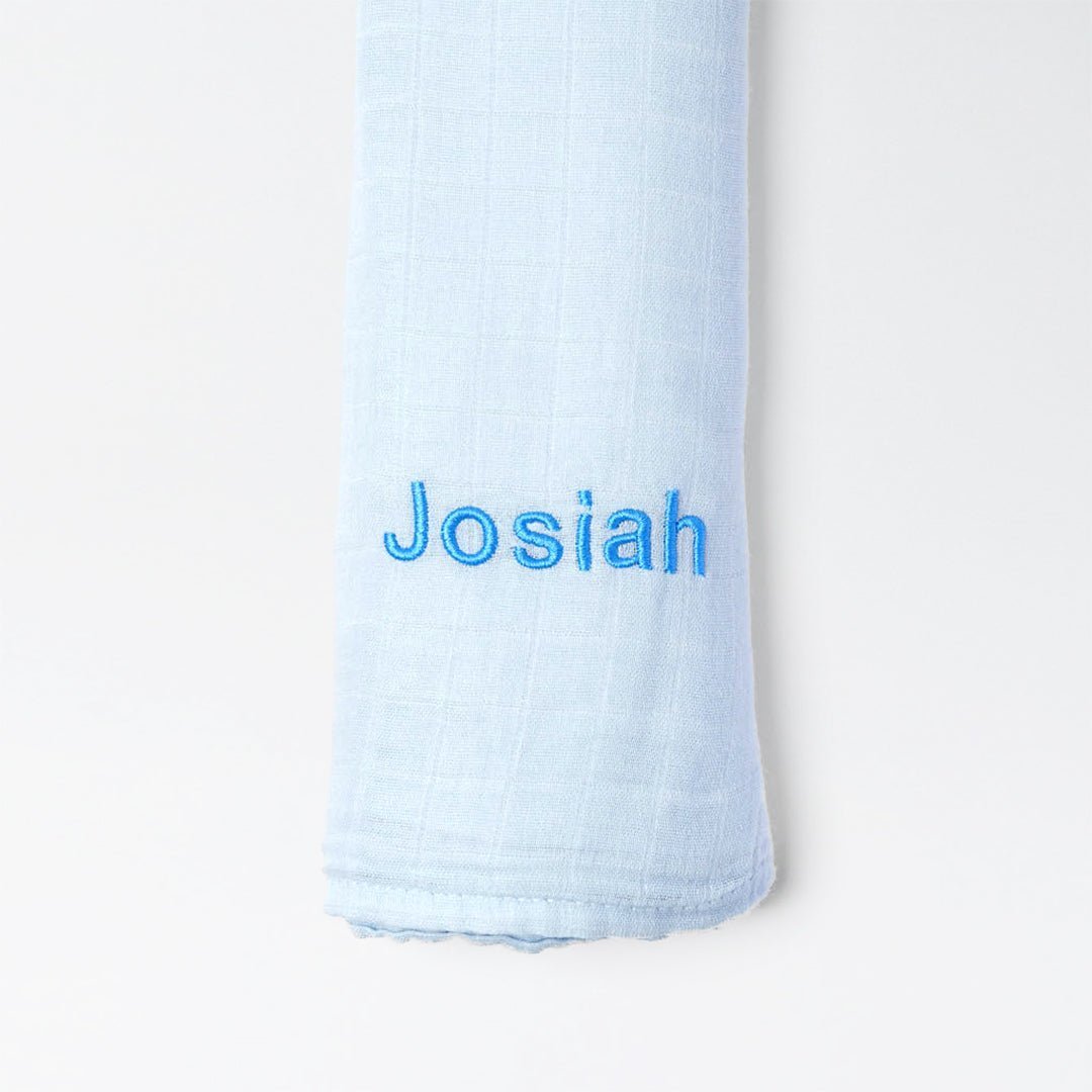 Blue bamboo muslin swaddle with "Josiah" personalised in blue thread