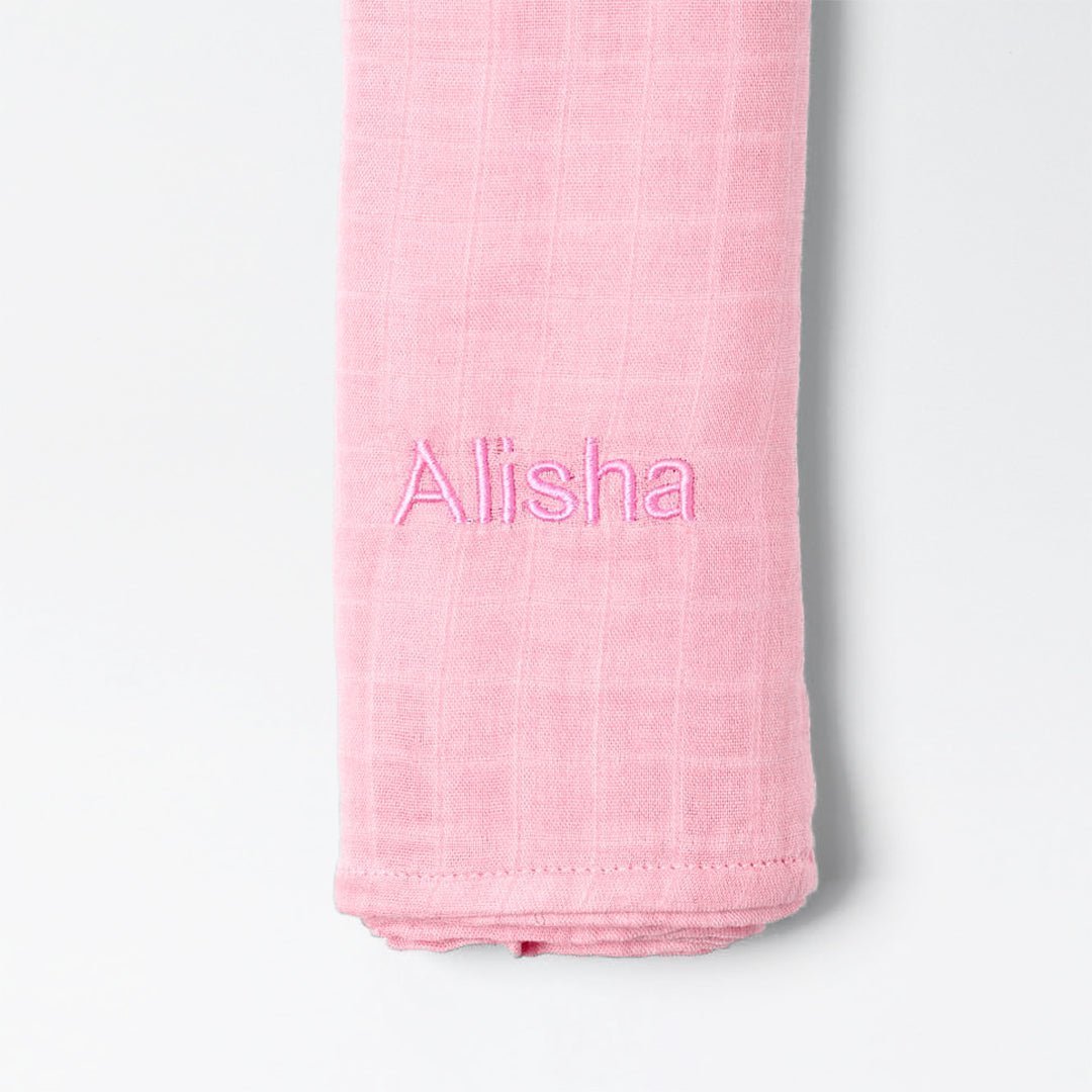 Pink bamboo muslin swaddle with "Alisha" personalised in pink thread