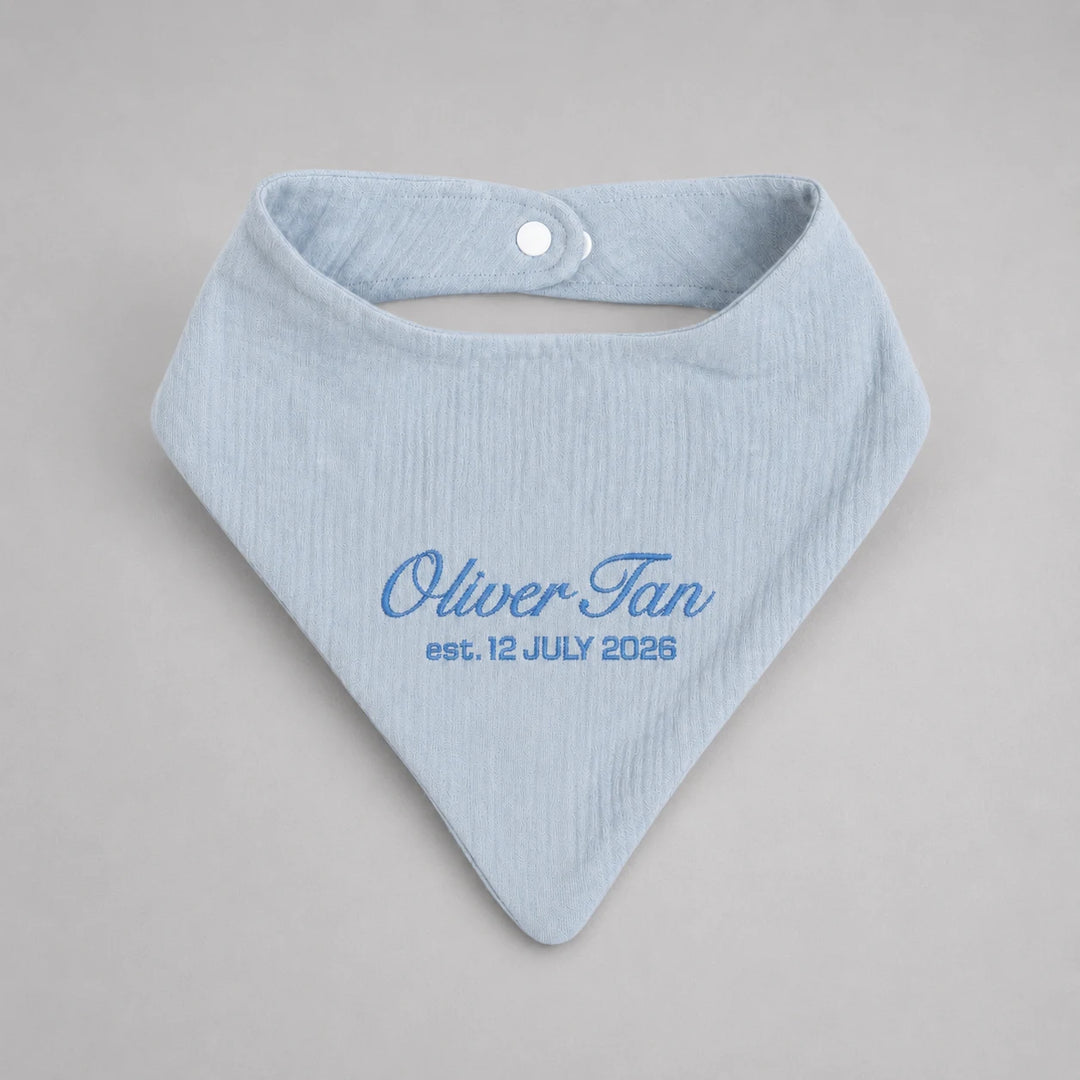 Personalised blue baby bib with embroidered name Oliver Tan and birth date