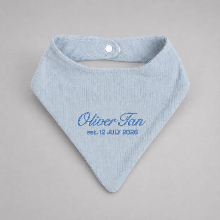 Personalised blue baby bib with embroidered name Oliver Tan and birth date