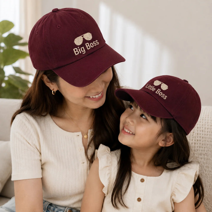 Woman and child wearing matching burgundy caps with 'Big Boss' and 'Little Boss' text.