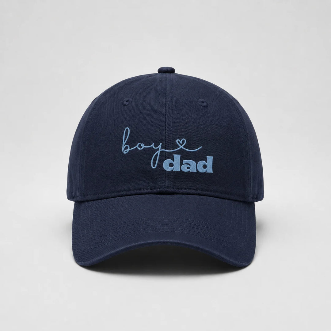 Navy blue cap with 'boy dad' text on a light gray background