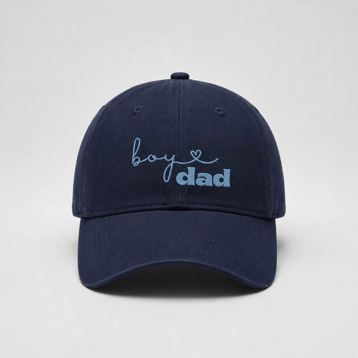 Navy blue cap with 'boy dad' text on a light gray background