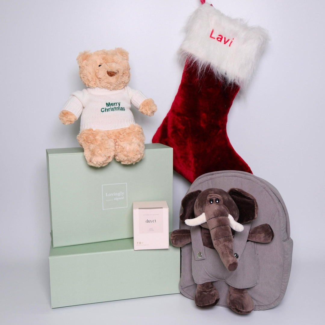 Christmas Themed Gift Hamper consisting of 4 products - Hugsy Teddy, red stocking, elephant backpack and soy candle