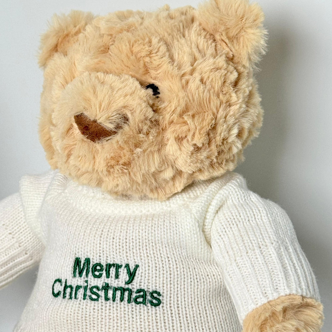 Up close of Hugsy Teddy wearing Cream jumper with "Merry Christmas" wordings