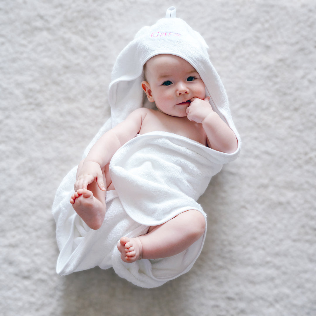 Baby wearing a hooded towel with the name "Gaia" embroidered on the hood