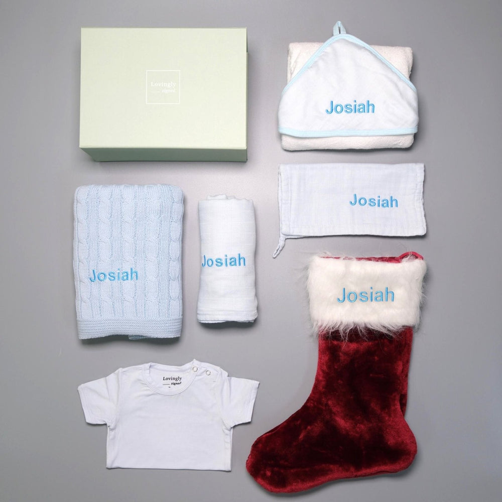 Christmas themed gift set in Blue consisting of hooded towel, muslin cloth, swaddle, cable knit blanket, Christmas edition babygrow and red stocking
