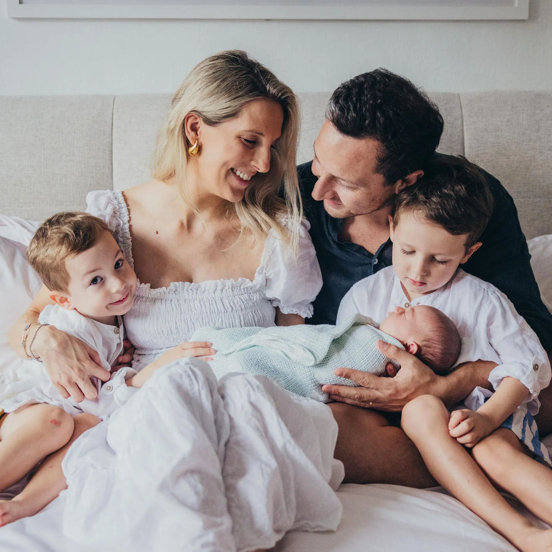 Family of five with a newborn baby on a bed, photographed by Katie Martin-Sperry Photography