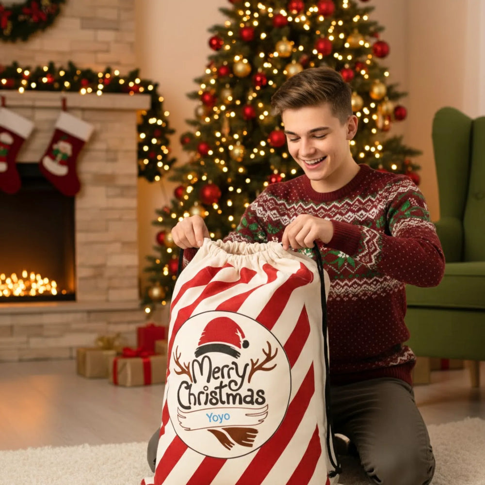 Man in festive sweater with a large Christmas sack in a decorated living room.