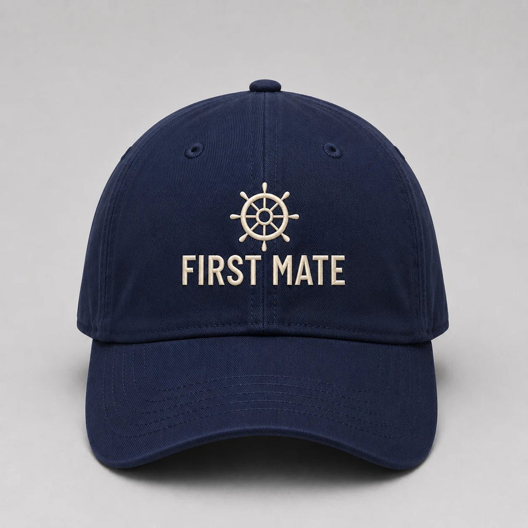 Navy blue cap with 'First Mate' and ship wheel emblem on a light gray background