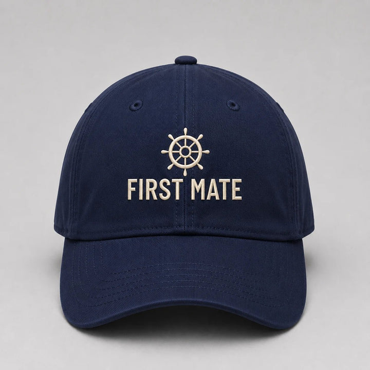 Navy blue cap with 'First Mate' and ship wheel emblem on a light gray background