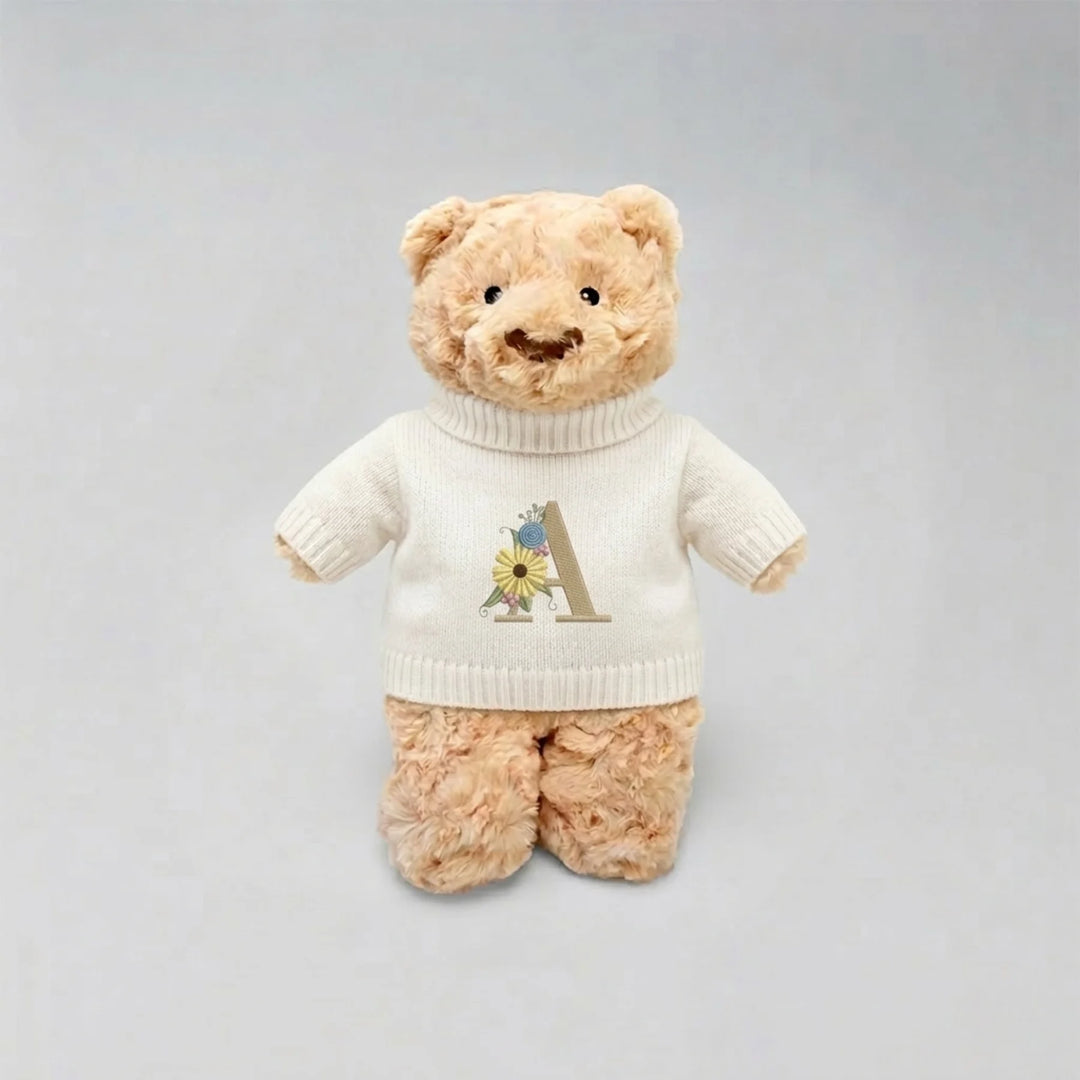Teddy bear wearing a personalised shirt with a letter 'A' on a gray background