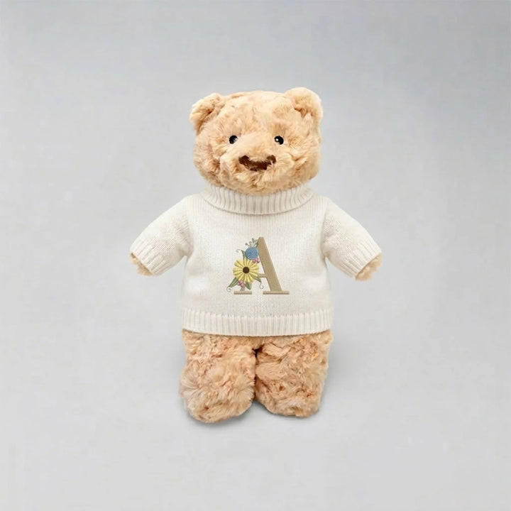 Teddy bear wearing a personalised shirt with a letter 'A' on a gray background
