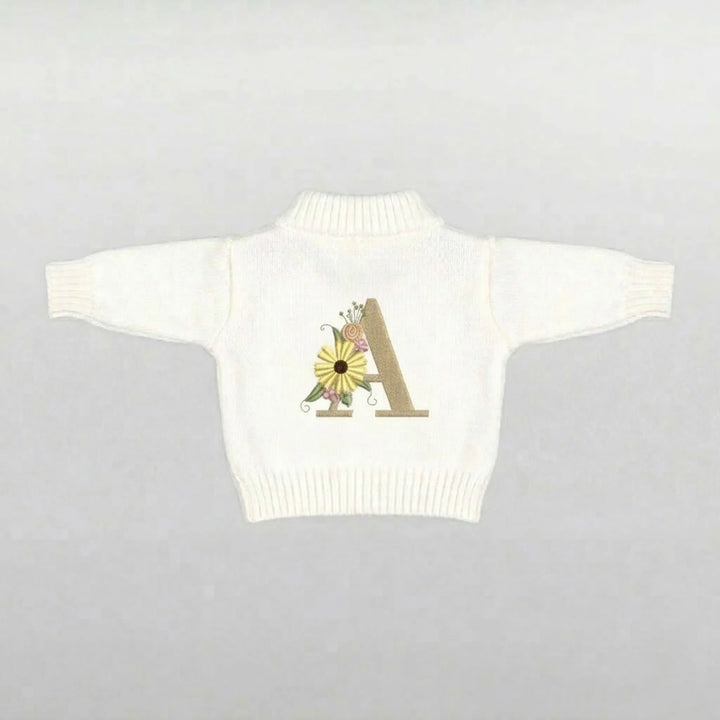 Cream Soft toy sweater with a floral design and letter 'A' 