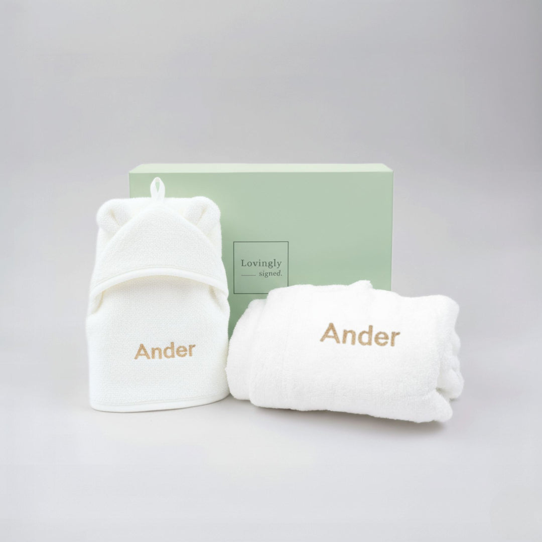 White baby outfit with 'Ander' branding on a light gray background
