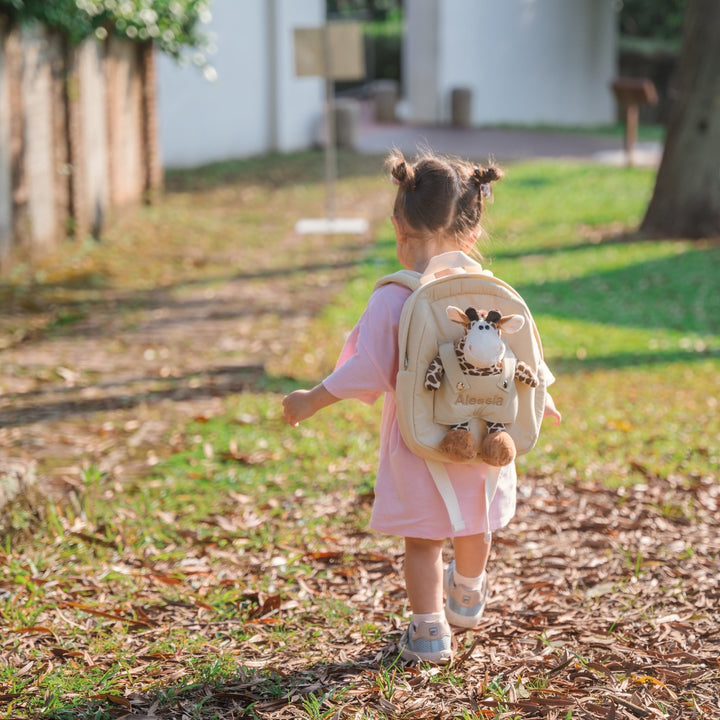 Toddler carring giraffe bag with "Alessia" personalised in beige thread