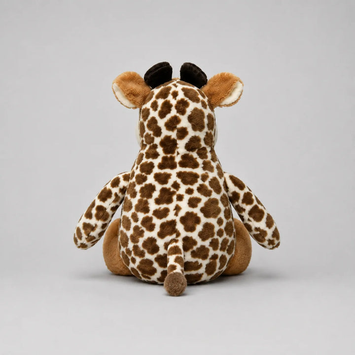 A plush giraffe toy shown from the back, featuring a brown and cream spotted pattern, tan ears and legs, and small black ossicones, photographed on a neutral light gray background.