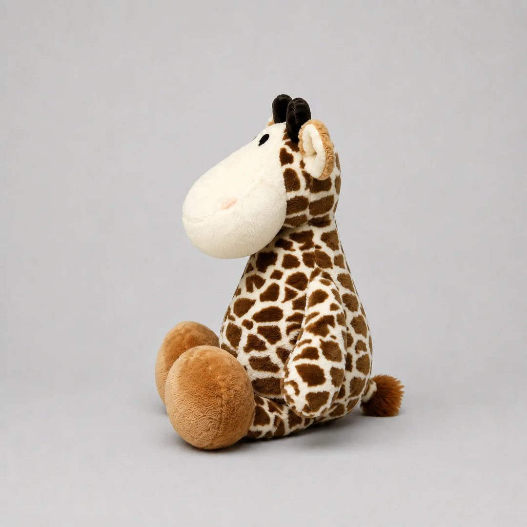 A plush giraffe toy sitting on a neutral gray background. The toy features a brown and cream patterned body, a large cream-colored snout, and brown ossicones on its head.