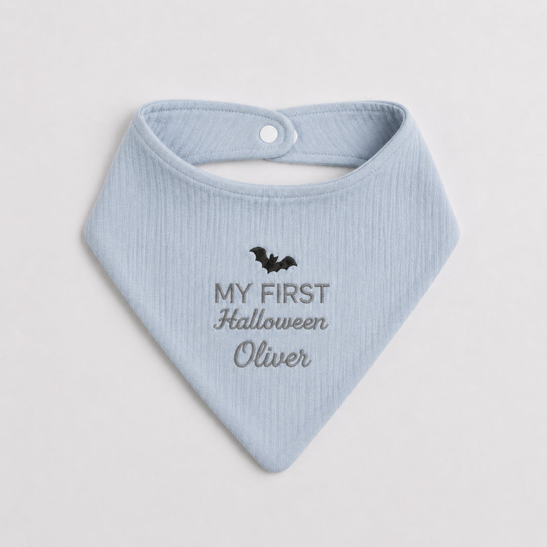 Personalised light blue baby bandana bib featuring a black embroidered bat, grey “My First Halloween” lettering and the name Oliver.