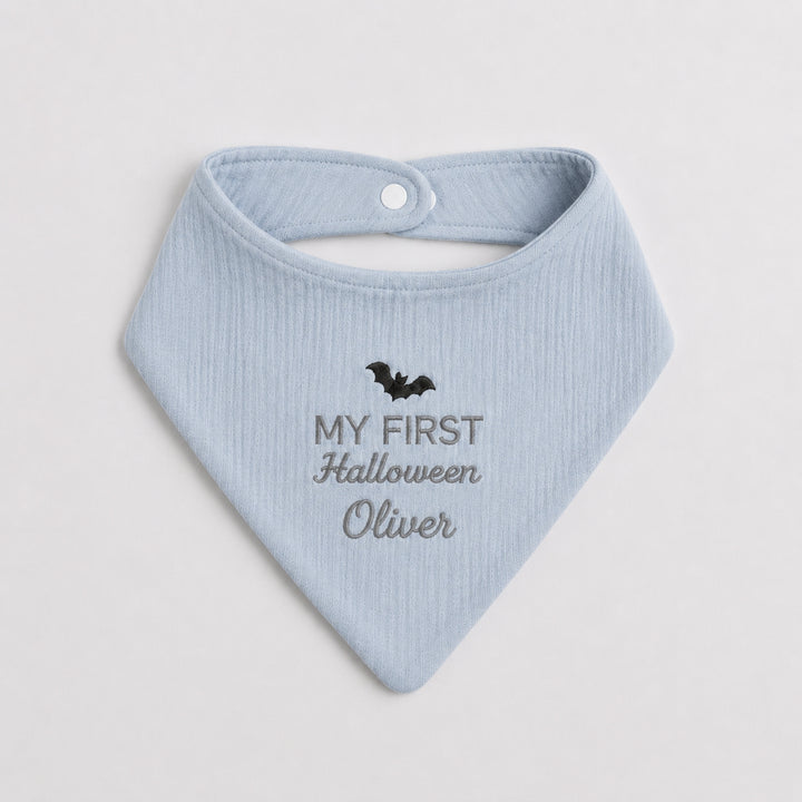 Personalised light blue baby bandana bib featuring a black embroidered bat, grey “My First Halloween” lettering and the name Oliver.