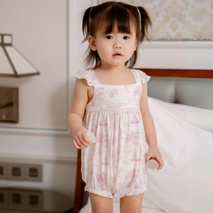 Baby wearing House of Holly Garden Toile Ruffle Bubble Romper in Pink